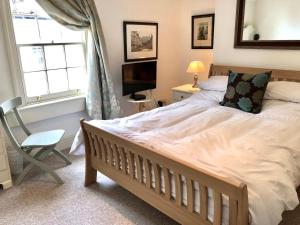 een slaapkamer met een bed, een stoel en een raam bij Lauras Townhouse Apartments Lansdown Slope Townhouse in Bath