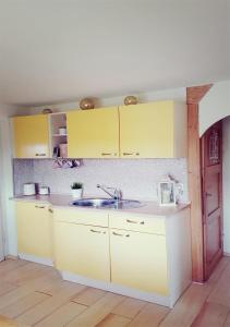 拉伯瑙的住宿－Ferienhaus Polly，厨房配有黄色橱柜和水槽