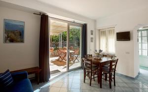 a living room with a table and chairs and a sliding glass door at Parco Vittoria Holidays House in Anacapri
