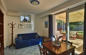 a living room with a blue couch and a table at Parco Vittoria Holidays House in Anacapri
