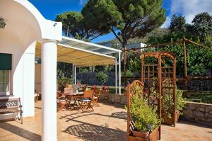 a patio with a pergola and a table and chairs at Parco Vittoria Holidays House in Anacapri