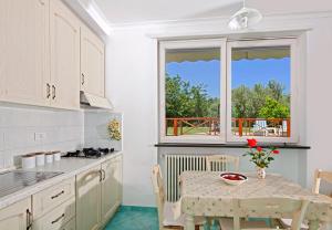 a kitchen with a table and a window at Parco Vittoria Holidays House in Anacapri +15 photos