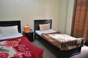 a hotel room with two beds and a red blanket at Zara Residence 1 in Swat +6 photos