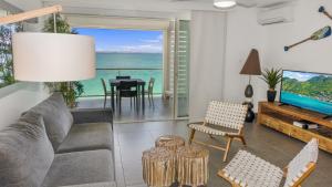 a living room with a couch and a tv and the ocean at Residence Bleu Marine - Honeymoon apartments in Saint Martin