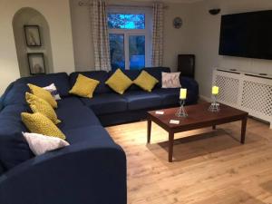 Sala de estar con sofá azul y mesa de centro en Atlantic Lodge, en Newquay
