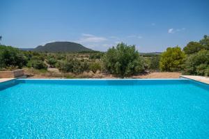 a blue swimming pool with a mountain in the background at Hotel Mas de la Costa **** in Valderrobres