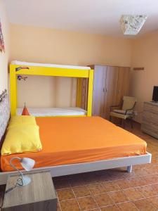 una camera con letto a baldacchino arancione e giallo di TROPEA BIANCA a Tropea