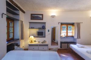 a bedroom with two beds and a tv on the wall at Casa Cassandra. Relax & Privacy ad un passo da Portofino in Paraggi