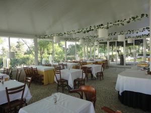 een restaurant met witte tafels, stoelen en ramen bij Hotel Rural Quinta de Santo Antonio in Elvas