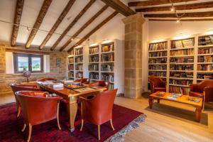 a dining room with a table and chairs and bookshelves at Hotel Mas de la Costa **** in Valderrobres