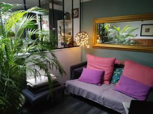 a living room with a couch and a mirror at Chez Anne in Fécamp