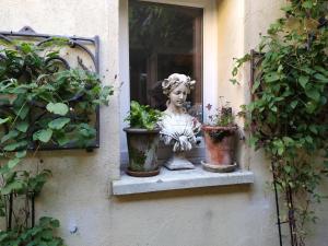 a statue sitting on a window sill with potted plants at Chez Anne in Fécamp