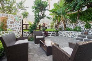 a patio with wicker chairs and a table at Apartamentos Los Telares in Hermigua