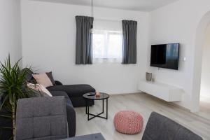 a living room with a couch and a tv at Apartment Stocic in Rogoznica