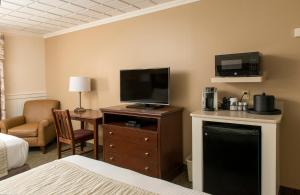 Habitación de hotel con cama y TV de pantalla plana. en Bird-in-Hand Family Inn en Bird in Hand