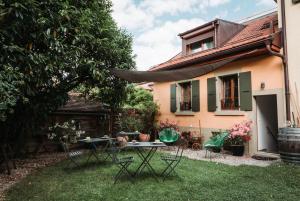 um quintal com cadeiras e mesas em frente a uma casa em B&B 7e Art em Vevey