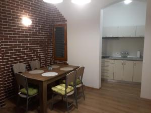 a kitchen with a table and chairs and a brick wall at A piece of history in Moscovitz Palace in Oradea