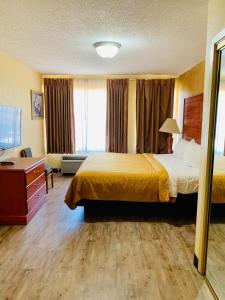 a hotel room with a bed and a desk at Coachman's Inn in Magnolia