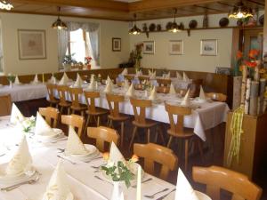 una sala da pranzo con tavoli e sedie con tovaglie bianche di Hotel-Gasthof Krone a Greding