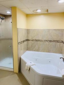 a bathroom with a bath tub and a shower at Coachman's Inn in Magnolia