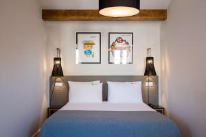 a bedroom with a bed with two lights and two pillows at Urbano FLH Hotels Lisboa in Lisbon