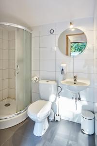 een witte badkamer met een toilet en een wastafel bij Metropolis Domki in Sopot