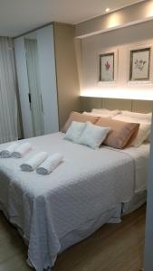 a bedroom with a large bed with white sheets and pillows at Loft Res Pedra Azul - hospedagem nas montanhas in Pedra Azul