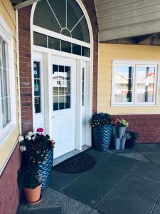 a front door of a house with pots of flowers at Hotel Vogar in Vogar