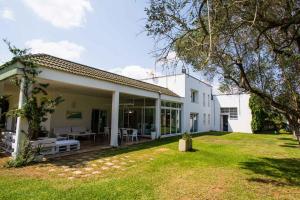 ein weißes Haus mit Rasen davor in der Unterkunft Luxury Villa Moruse in Melendugno