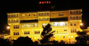 un edificio de hotel por la noche con un cartel de hotel en Hotel San Rosendo, en Ourense