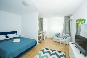 a bedroom with a bed and a tv and a couch at Residence DP Pipera in Bucharest