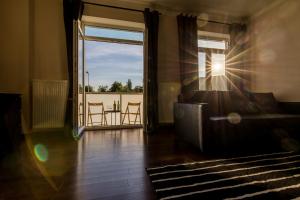 a living room with a couch and a view of a balcony at Rezidence Moser Apartments in Karlovy Vary
