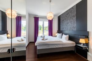 2 letti in una camera con tende viola di Rezidence Moser Apartments a Karlovy Vary