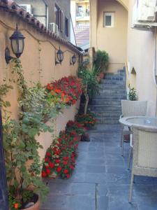 un patio con flores rojas, una mesa y escaleras en B & B 903ta, en Skopje