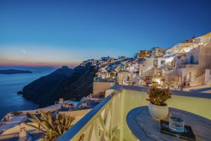 balcón con mesa y vistas al océano en Mirabo Villas, en Firostefani