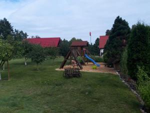 a park with a playground with a slide at Pokoje w lesie in Miłomłyn