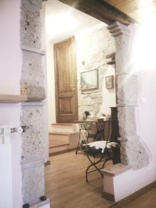 a living room with a stone wall and a door at 4 Assi in Pitigliano