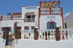 a white house with a red and white fence at Maryloujohn Villas Oia in Oia