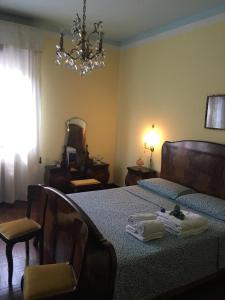 a bedroom with a bed with a chair and a chandelier at Alla Rotonda dai Santi in Rovigo