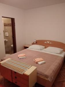 a bedroom with a large bed with two towels on it at Soba Željka in Bribir