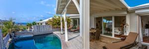 - deux vues sur une maison avec une piscine dans l'établissement Villa La Voile Blanche, à La Baie-Orientale