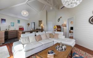 ein Wohnzimmer mit einem weißen Sofa und einem Tisch in der Unterkunft Villa La Voile Blanche in Orient Bay French St Martin