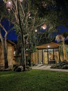 dom z drzewem w ogrodzie w nocy w obiekcie Villa Armonia Hotel & Spa w mieście Jocotepec