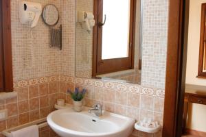 a bathroom with a sink and a mirror at Hotel Il Cortile in Custonaci