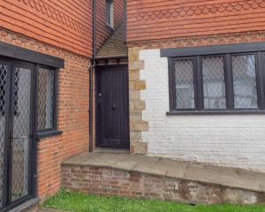 a brick building with a black door and windows at 2 Ringles Place in Uckfield