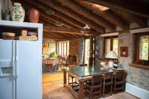 a kitchen with a table and a white refrigerator at Charming Boutique Country House: La Casa Vieja (Sotosalbos) in Sotosalbos