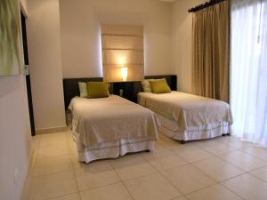 pokój hotelowy z 2 łóżkami i oknem w obiekcie Condominos Las Ventanas w mieście Paraíso