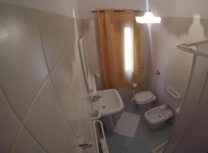 a small bathroom with a sink and a toilet at Hotel Il Cortile in Custonaci