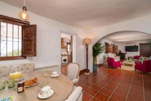 cocina y sala de estar con mesa y sillas en Villa with views and private pool near Malaga., en Colmenar