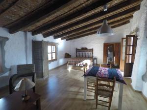 ein Wohnzimmer mit einem Tisch und einem Bett in der Unterkunft Casa de Cáliz Xàtiva in Xàtiva